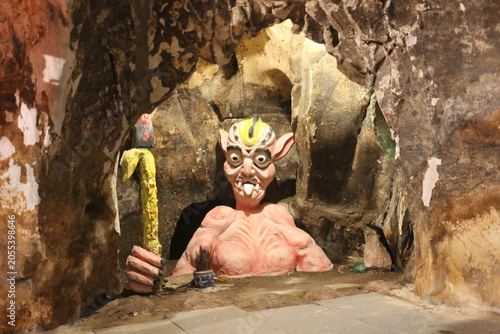 Schilderij op canvas Sculpture of mythical creature in cave chamber with red and yellow lighting