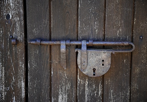 Canvas Print Antique weathered wooden entrance door with a rusty vintage pewter closure and lock in Savoca Sicily, Italy