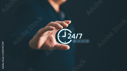 Obraz na plátně Businessman hand holding glowing 24 hrs service icon with contact channels