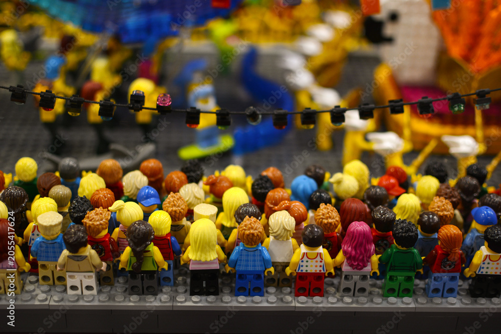 Naklejka premium A group of plastic toy miniature figures of people standing together. Lego exhibition. Poland. Warsaw.