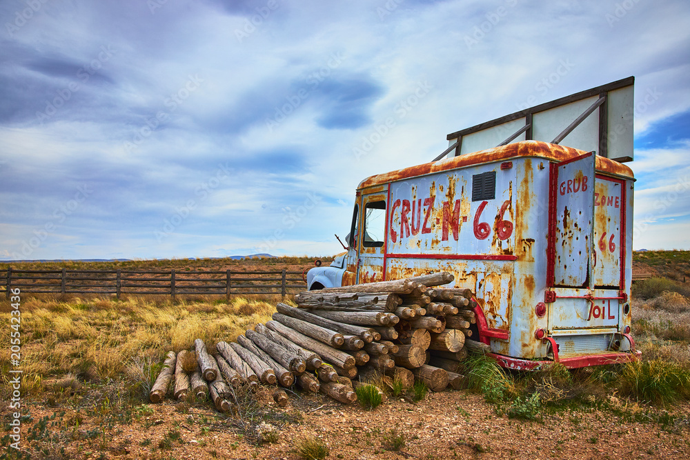 Fototapeta premium Rustic Vintage Truck and Logs on Route 66 in Arizona Countryside
