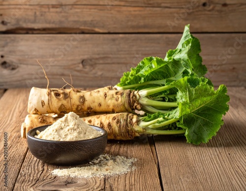 Fresh horseradish roots with grated powder in bowl on rustic wooden table, natural light kitchen scene