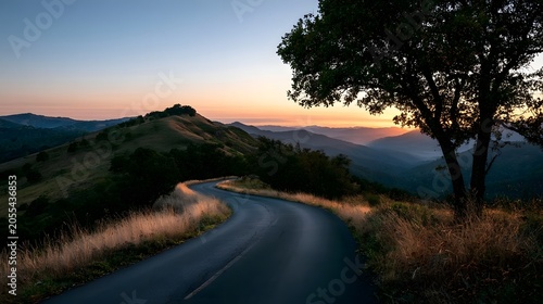 A winding mountain road bathed in the warm glow of the sunset creating a picturesque and exploratory landscape
