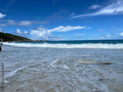 The beautiful Grand Ance Beach on La Digue Island in the Seychelles. Turquoise sea, waves, huge cliffs, white sand