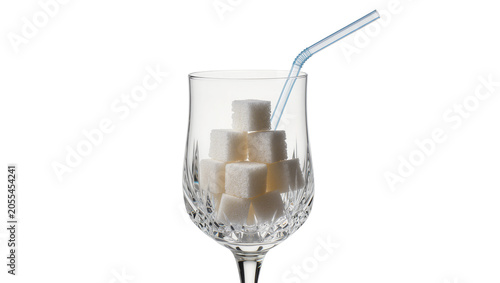 Foto Isolated crystal glass full of refined white sugar cubes with a drinking straw