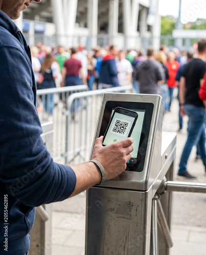 Scanning QR code ticket at stadium entrance turnstile, event access, digital ticket entry, mobile boarding pass, sports game, concert, festival, with copy space