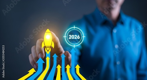 Businessman's hand ignites a rocket taking off from a chart of rising arrows, targeting 2026 for future business growth, innovation, and strategic success.