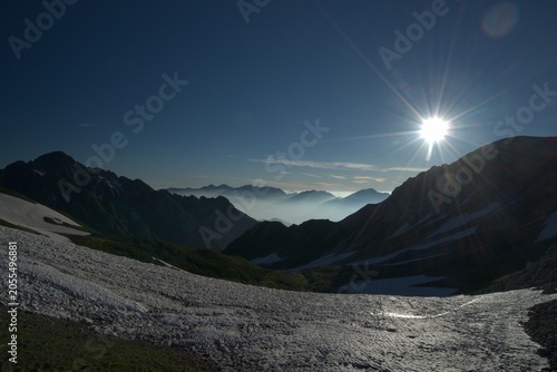 Canvas-taulu Sun over snowy mountain valley in summer, Japan