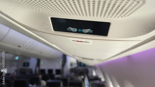 Photography Illuminated airplane fasten seat belt sign inside aircraft cabin, passenger safe