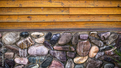 Fotografija A horizontal split view showing a rustic structure with warm orange wooden sidin