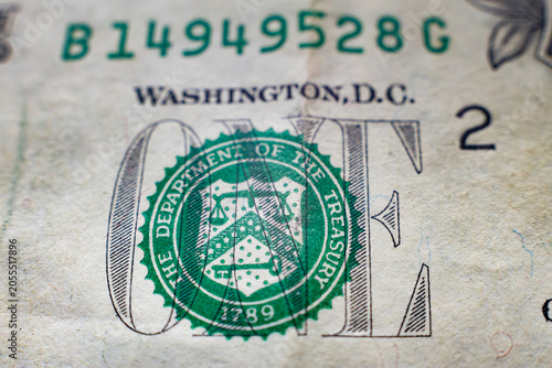 Macro shot of the US department of the treasury green seal on a one dollar bill