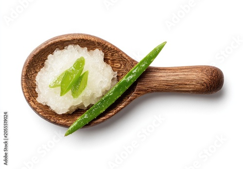 Wooden spoon holding grated food and green vegetable isolated on white backdrop