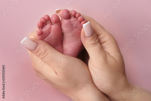 Newborn baby feet held in mother's hands