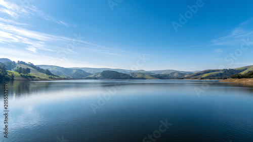 Serene lake reflecting clear blue skies and lush greenery, perfect for nature lovers and peaceful escapes into the outdoors.