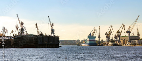 Bild auf Leinwand Saint Petersburg, Russia: Ultra wide panoramic view of Baltic Shipyard with cranes, dock infrastructure and cargo vessel on Neva River