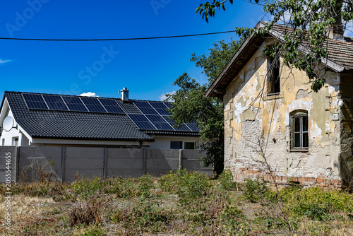 Contrast of eras: abandoned building vs. modern eco-friendly house
