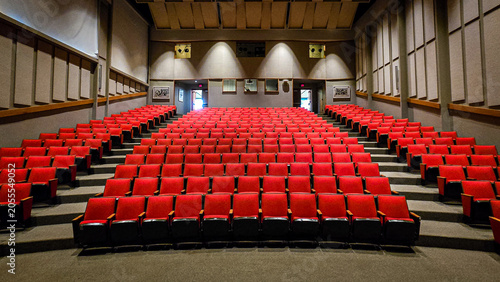 Empty movie theater auditorium with red velvet seats