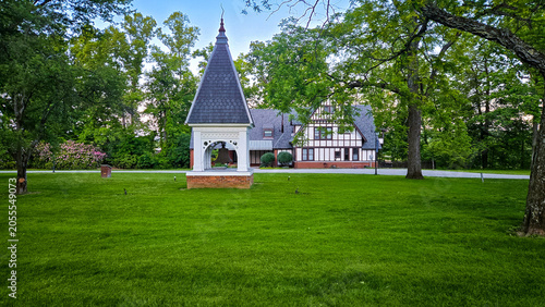 Historical bell tower in a park setting with old manor house