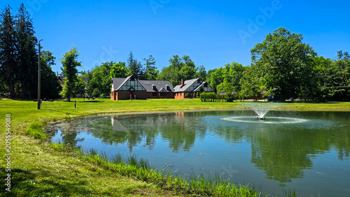 Tudor style cottages by a pond with fountain in a park