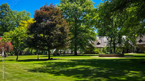 Green campus park with historic buildings and vintage clock tower