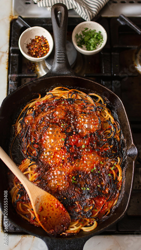 Spaghetti all Assassina Bubbling in Cast Iron Skillet on Stove