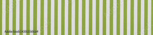 Seamless pattern of vertical light green and white textile stripes on textured awning canvas fabric background