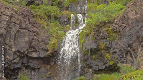 Mountain stream flowing over rocks in a green landscape in nature