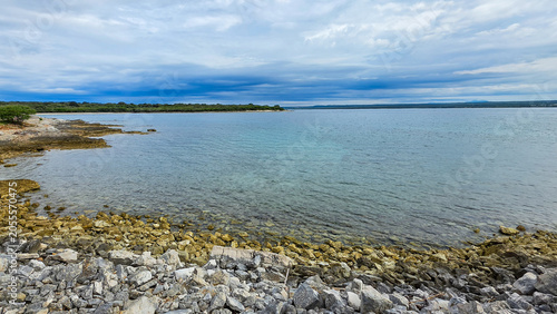 Rocky Seashore with Clear Blue Water and Overcast Sky