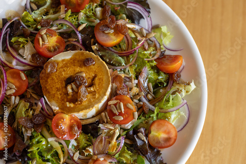 Goat cheese salad with cherry tomatoes, red onion and sunflower seeds
