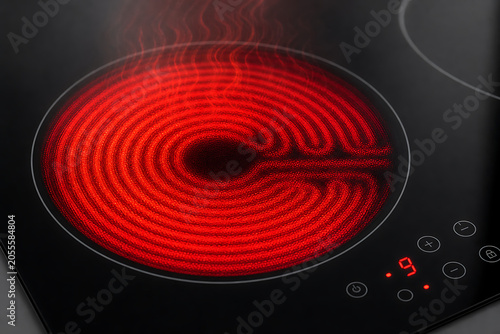 Induction Cooktop Heating with Red Glowing Coil and Black Surface Close-Up