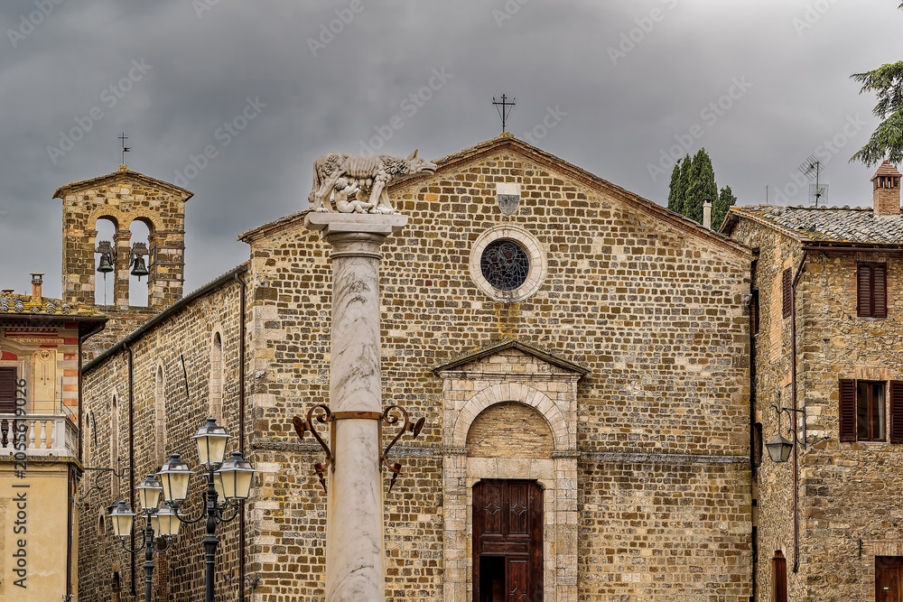 Naklejka premium Alte Steinfassade der Kirche Sant'Egidio mit der Wölfin-Säule in Montalcino, Toskana, Italien / Stone facade of Sant'Egidio church with she-wolf column in Montalcino, Tuscany, Italy