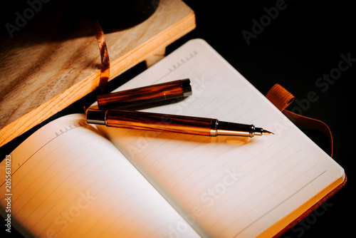 Warm glow on a sophisticated fountain pen and open journal pages