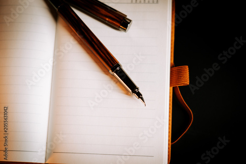Elegant fountain pen rests on open lined notebook, ready for writing on a quiet evening