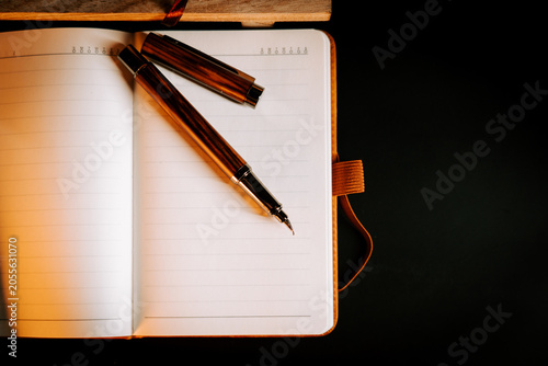 Elegant fountain pen rests on open lined notebook ready for new writing
