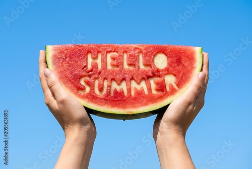 Hands hold juicy watermelon slice with hello summer carved into flesh against clear blue sky bright sunny day refreshing fruit treat for vacation.