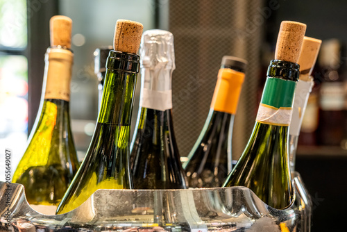 Assortment of Wine and Champagne Bottles With Corks in a Chilled Metal Ice Bucket
