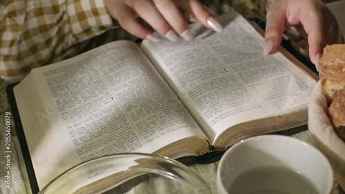 young conservative asian Woman Reading the Bible at table with bread food and drink indoors