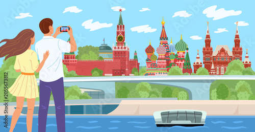 Tourists, a man and a woman, take pictures of the Moscow Kremlin, St. Basil's Cathedral, and the Historical Museum in Moscow on Red Square