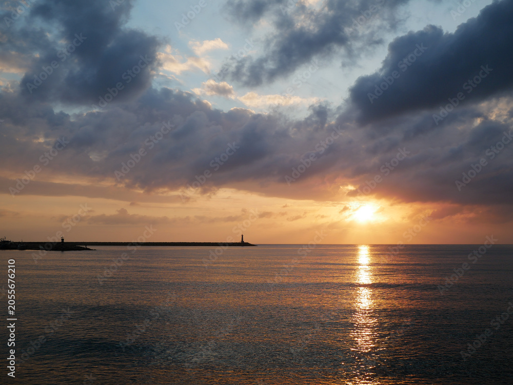 Obraz premium Dramatic Sunset Over Calm Sea with Golden Reflection on Water