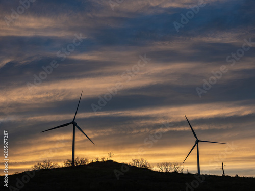 Sunset with wind turbines on a mountain.in
