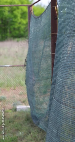 Green shade net on fence waving in the wind