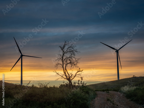 Sunset with wind turbines on a mountain.in