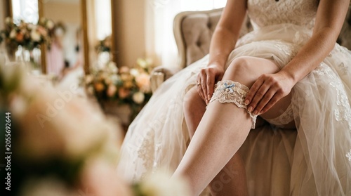 Noiva colocando a liga, um detalhe íntimo e tradicional do casamento.