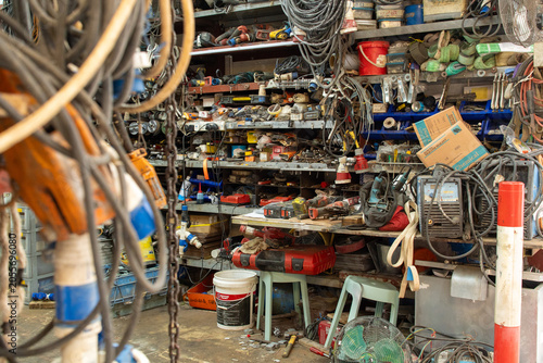 Cluttered workshop with electrical tools cables and equipment in organized industrial storage space
