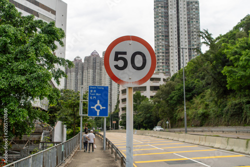 Foto Urban speed limit sign 50 on city street near high rise buildings with pedestria
