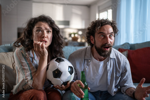 Φωτογραφία Couple watching soccer game at home feeling suspense