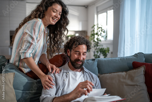 Fotografía Couple laughing while reliving happy memories from photo album