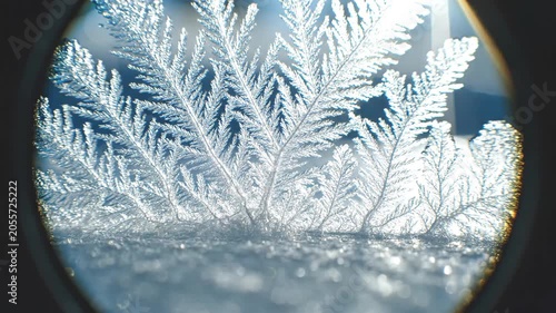 Extreme macro timelapse of crystalline frost growing under microscope with volumetric ice blue sunbeams