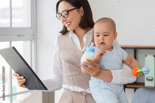 Working mother holding baby...