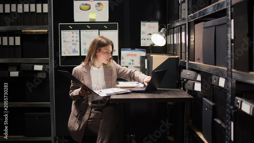 Fotografie Law officer entering room, using laptop to analyze clues and perform comprehensive investigation
